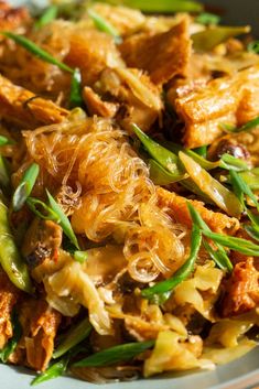 a close up of a plate of food with meat and green beans on the side