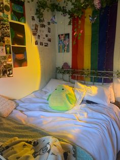 a bed with a stuffed animal sitting on top of it next to a rainbow flag