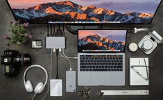 a laptop computer sitting on top of a desk next to headphones and other electronics