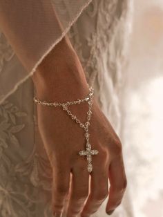 a close up of a person wearing a cross bracelet