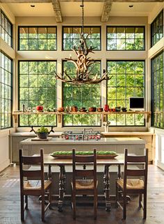 a dining room table with chairs and a chandelier hanging from it's ceiling