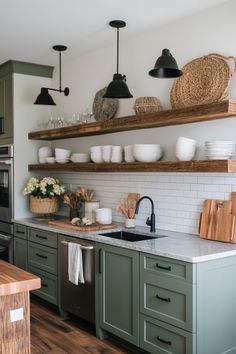 the kitchen is clean and ready to be used for cooking or baking, with green cabinets and white subway backsplash