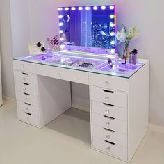 a white vanity with drawers and lights on it