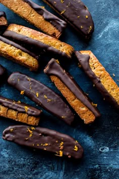 an assortment of cookies with chocolate drizzled on them and sprinkled with orange zest