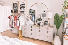 a bedroom with a dresser, mirror and pictures on the wall