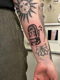 a person with a tattoo on their arm holding up a clock and sun in the background