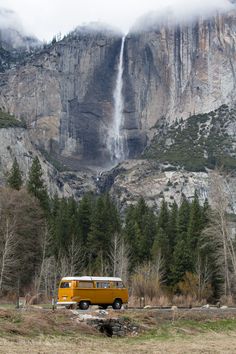 a yellow van parked in front of a waterfall