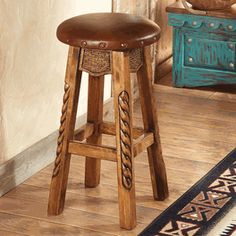 a wooden stool sitting on top of a hard wood floor next to a blue dresser