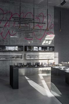 the interior of a restaurant with graffiti on the wall and counter tops in grey tones