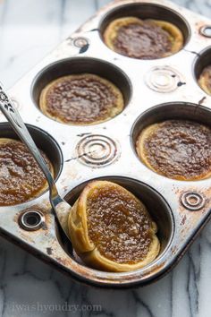 a muffin tin filled with cupcakes sitting on top of a marble counter