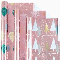 pink wrapping paper with christmas trees and snowflakes on them, set against a white background