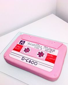 a pink cassette shaped cake sitting on top of a table