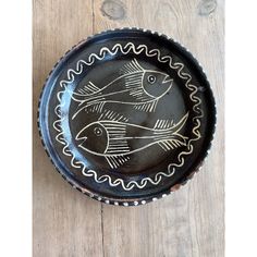 a black and white bowl with fish on it