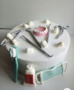 a cake decorated with dental instruments and toothbrushes