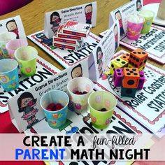 a table topped with dices and cups filled with different colored paper items on top of it