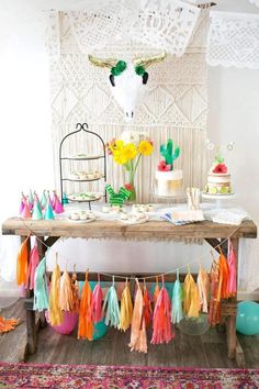 a table topped with cake and tassels next to a cow head on top of a wall