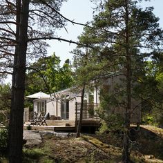 there is a small house in the middle of the woods with a deck and picnic table