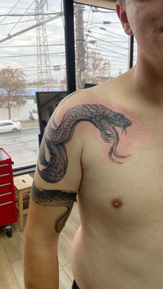 a man with a snake tattoo on his chest