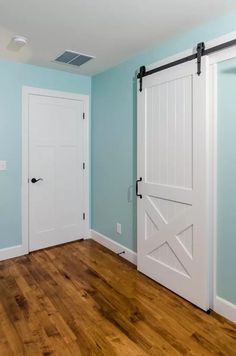 an empty room with blue walls and white doors