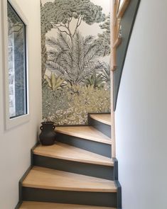 there is a vase sitting on the stairs next to the wall with trees painted on it