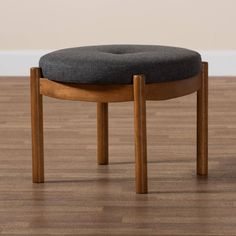 a small stool with a black cushion on it