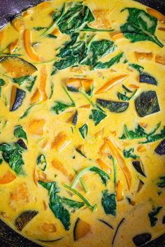 an omelet with spinach, carrots and cheese in a skillet