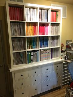 a white bookcase filled with lots of books