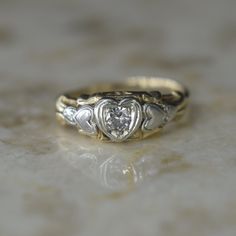 a gold and white diamond ring sitting on top of a table