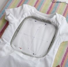 a baby's bodysuit is being sewn on by someone using scissors and thread