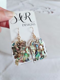 a pair of earrings is shown in front of a card