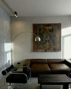 a living room filled with furniture and a painting on the wall