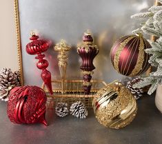 there are many christmas ornaments on the table next to each other, including balls and pine cones