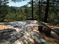 a wooden deck in the middle of some trees