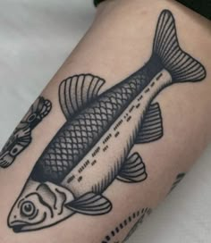 a black and white fish tattoo on the arm