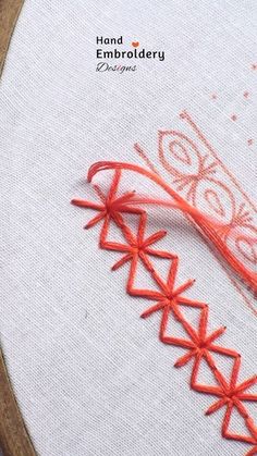 an embroidery project with red thread and orange stitching on the bottom half of it