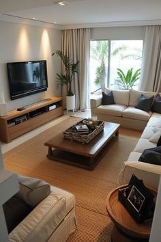 a living room filled with furniture and a flat screen tv mounted on a wall above a wooden coffee table