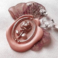 a close up of a wax seal with flowers on it