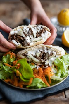 two pita sandwiches on a plate with lettuce, carrots and cheese