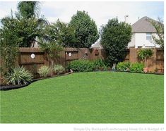 a backyard with green grass and wooden fence