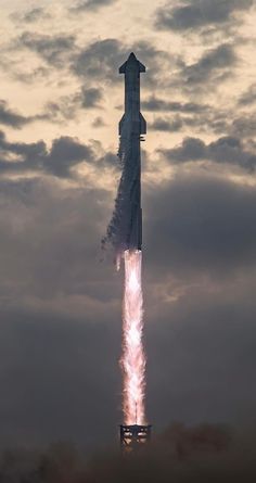 a rocket launching into the sky with clouds in the background