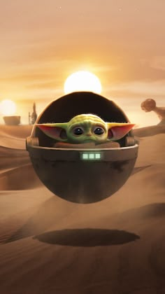 the child yoda is floating in an egg shaped pod on top of sand dunes