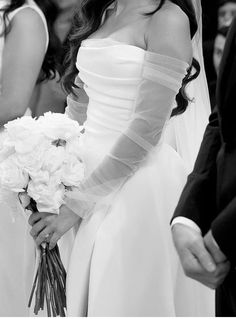 a woman in a wedding dress holding a bouquet