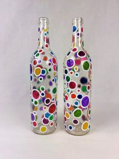 two glass bottles with multicolored circles on them