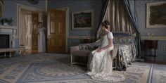 a woman in a wedding dress sitting on a bed