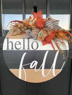 a door hanger with the words hello fall painted on it, and a bow