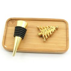 a wooden tray with a bottle stopper and a gold christmas tree on it's side