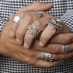 the man is holding his hands together with rings on each hand and an elephant ring