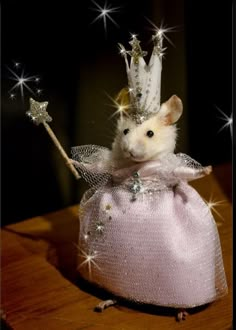 a small mouse in a pink dress with a crown on top of it's head