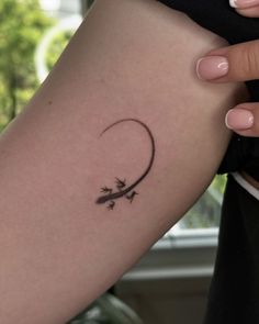 a woman's arm with an arrow tattoo on the left side of her body