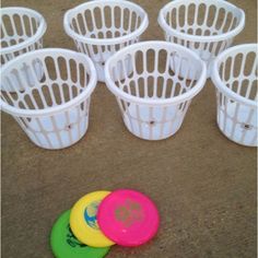 several plastic cups and frisbees sitting on the ground next to each other